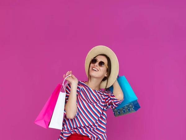 ピンクの背景にショッピングバッグを持つ若い女性 大販売の1日後に新しい購入でポーズをとっている幸せな女の子 ブラック フライデーのコンセプト — ストック写真
