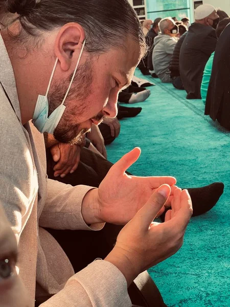 Ton sombre, homme musulman priant avec des perles de chapelet dans les mains sur fond noir. Concept de religion, mains priantes. — Photo
