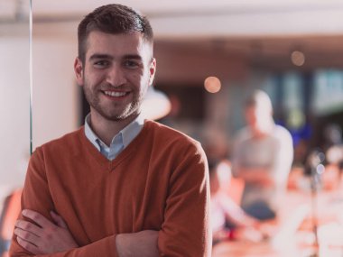 Yakışıklı genç iş adamı ekibinin önünde kendinden emin duruyor.