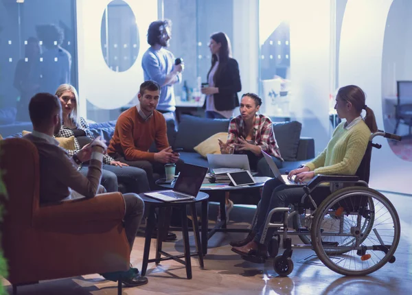 Handikapperd affärskvinna i rullstol på möte med hennes mångsidiga affärsteam brainstorming på kontoret — Stockfoto