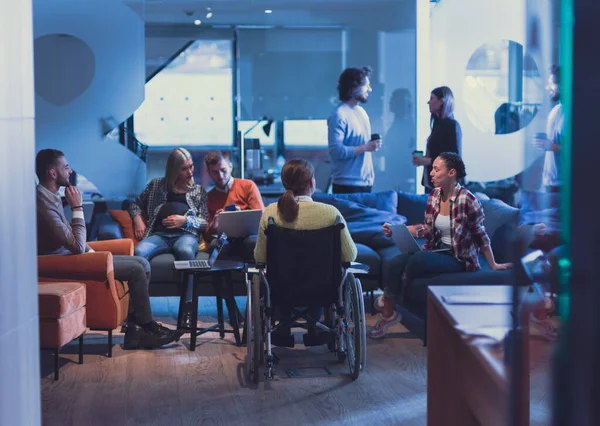 Handicapperd donna d'affari in sedia a rotelle su un incontro con il suo team di lavoro diverso brainstorming in ufficio — Foto Stock