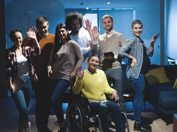 Empresaria discapacitada en silla de ruedas en la oficina con equipo de compañeros de trabajo — Foto de Stock