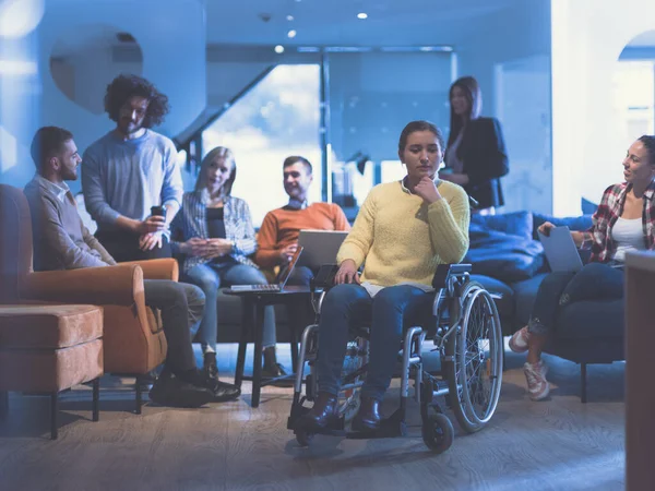 Portret van een gehandicapte zakenvrouw in een rolstoel voor haar divers business team op kantoor — Stockfoto