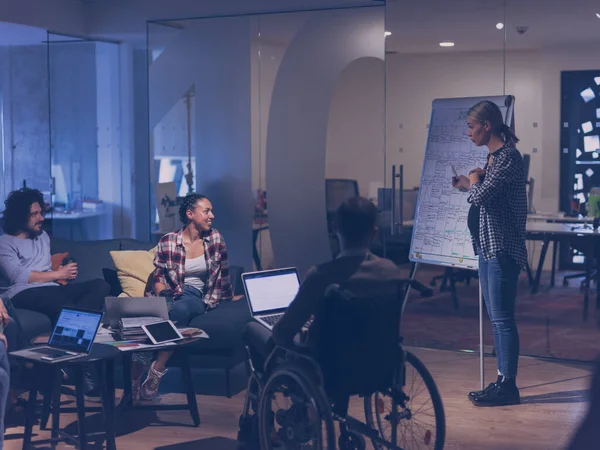 Disabled businessman in a wheelchair at work in modern open space coworking office with team — Stock Photo, Image