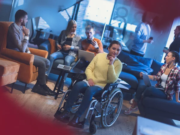 Portret van een gehandicapte zakenvrouw in een rolstoel voor haar divers business team op kantoor — Stockfoto