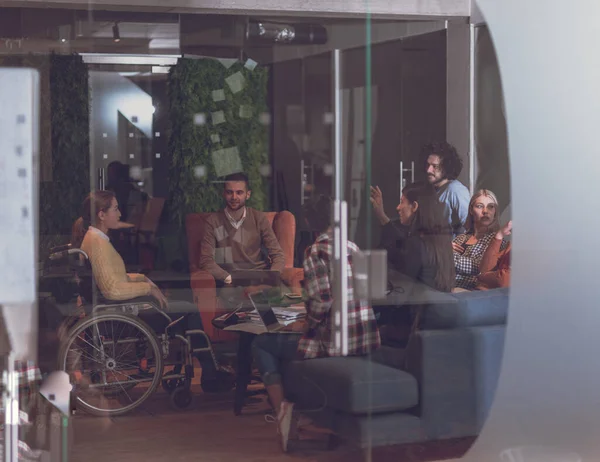 Geschäftsfrau im Rollstuhl bei Geschäftstreffen mit Team im modernen Büro — Stockfoto