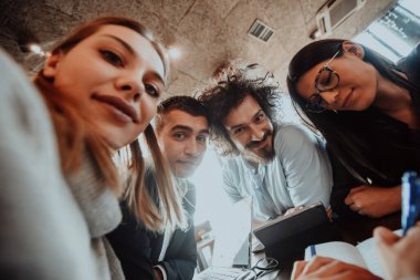 Modern bir ofiste oturan bir grup girişimcinin çılgın portresi..