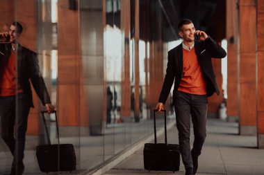 Havaalanı terminaline gidiyorum. Kendine güvenen iş adamı sokaklarda yürüyor ve bavulunu çekiyor. Kahve içiyor ve akıllı telefondan konuşuyor.