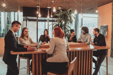Bir grup arkadaş bir kafede dizüstü bilgisayarla takılıyorlar. Lokantada dizüstü bilgisayar kullanan mutlu gençler.