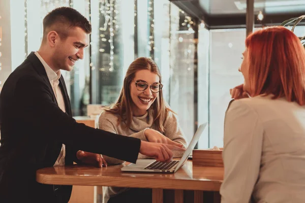 Un grupo de amigos pasando el rato en un café, y hablando de negocios — Foto de Stock