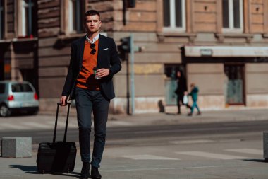 Havaalanı terminaline gidiyorum. Kendine güvenen iş adamı sokaklarda yürüyor ve bavulunu çekiyor. Kahve içiyor ve akıllı telefondan konuşuyor.