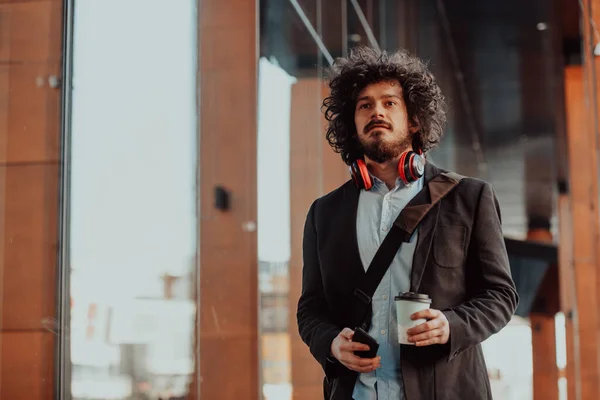 Feliz joven americano sosteniendo un café. Con auriculares. Estudiante chico. —  Fotos de Stock