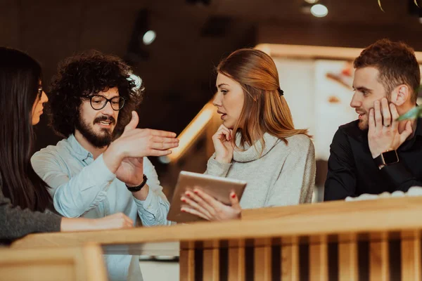 Un grupo de personas en una pausa para el café usan computadoras portátiles, tabletas y teléfonos inteligentes mientras discuten nuevos proyectos de negocios. concepto de negocio. —  Fotos de Stock