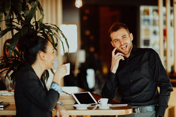 Dos jóvenes en un descanso del trabajo en un café toman un descanso de las obligaciones cotidianas. —  Fotos de Stock