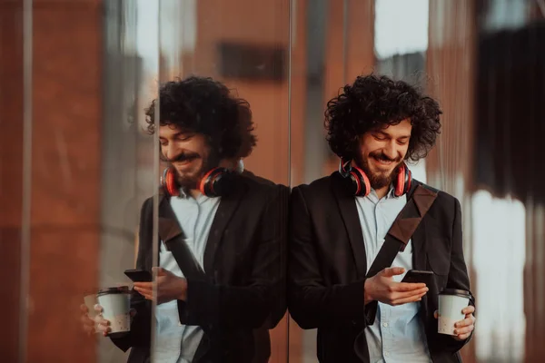 Feliz joven americano sosteniendo un café. Con auriculares. Estudiante chico. —  Fotos de Stock