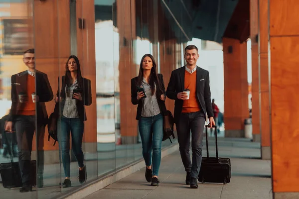 Geschäftsmann und Geschäftsfrau reden und halten Gepäck, das auf einer Geschäftsreise unterwegs ist, mit frischem Kaffee in der Hand.Geschäftskonzept — Stockfoto
