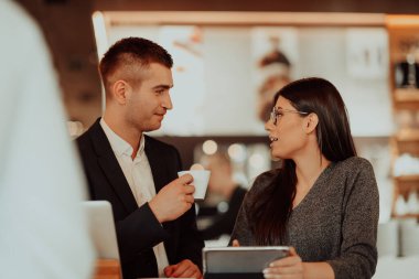 Modern erkek ve kadın kahve dükkanında modern cihazlar, dizüstü bilgisayar, tablet ve akıllı telefon kullanırlar. 