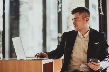 Kafeteryada dizüstü bilgisayarı ve akıllı telefonu olan bir iş adamı oturuyor. Bir barda otururken akıllı telefondan mesaj atan bir iş adamı. İşadamı bilgisayarda çalışıyor ve e-postaları kontrol ediyor.