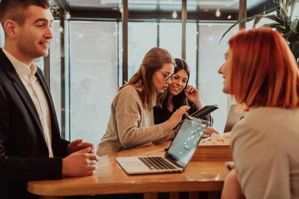 Un grupo de amigos pasando el rato en un café, y hablando de negocios — Foto de Stock