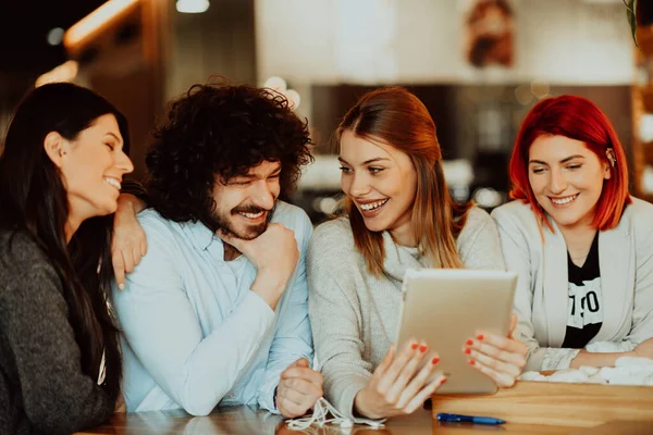 Um grupo de amigos saindo em um café, e entre eles está um tablet. — Fotografia de Stock