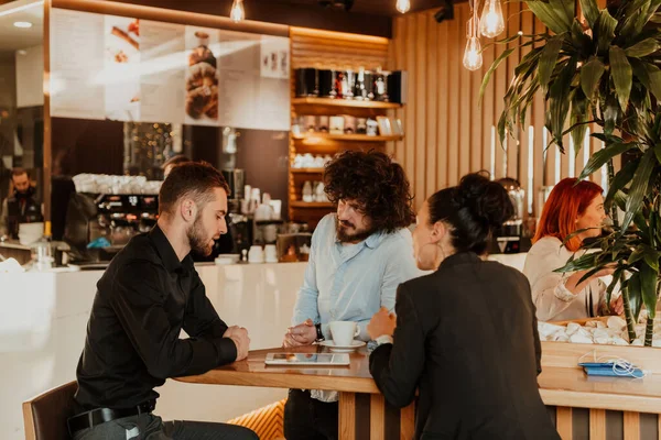 A group of friends hanging out in a cafe, and among them is a tablet. — Stock Photo, Image
