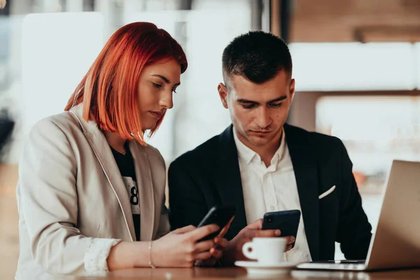 Homem e mulher modernos usam dispositivos modernos, laptop, tablet e smartphone na loja coffe — Fotografia de Stock