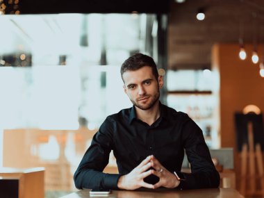 İş konsepti. Genç bir girişimci bir kafede oturur ve yeni iş fikirleri düşünür..