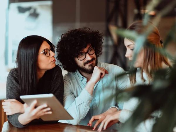 Eine Gruppe von Freunden hängt in einem Café herum und unterhält sich über Geschäfte — Stockfoto