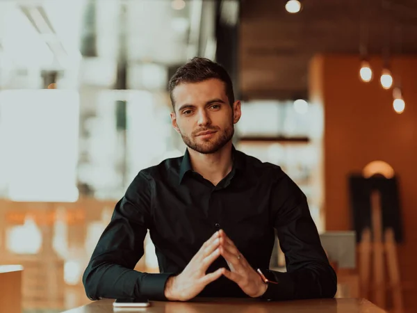 Uomo d'affari siede in un caffè e la sua mano simboleggia il successo — Foto Stock