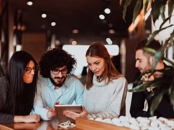 Um grupo de pessoas em uma pausa para café usam laptops, tablets e smartphones enquanto discutem novos projetos de negócios. conceito de negócio. — Fotografia de Stock