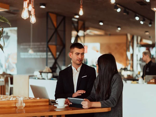 Homem e mulher modernos usam dispositivos modernos, laptop, tablet e smartphone na loja coffe — Fotografia de Stock