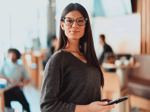 Retrato de muito jovem empresária olhando para a câmera enquanto segurava tablet digital em pé no escritório.. — Fotografia de Stock