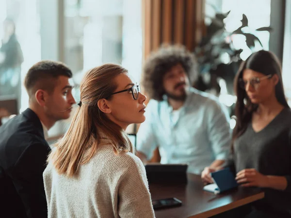 Eine Gruppe junger Unternehmer diskutiert in einer Kaffeepause das Projekt mit modernen Redaktionstablets, einem Smartphone und einem Laptop. — Stockfoto