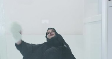 Geleneksel tesettürlü Müslüman kadın cam zeminde dua ediyor.