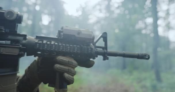 Soldado moderno con rifle en guaridas bosque con humo en backgorund — Vídeo de stock