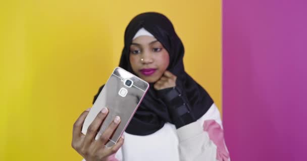아프리카 무슬림 여성이 웃으며 스마트폰으로 셀카를 찍는 모습 — 비디오