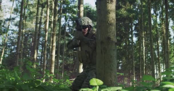 빽빽 한 숲 속에서 군복을 입고 군사 행동을 할 준비가 된 군인의 모습 — 비디오