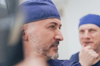 Ortopedist doktor ekibi klinikte ya da hastanede dijital röntgen filmini inceliyor.