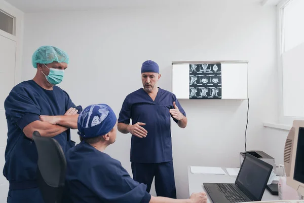 Equipo médico ortopedista que examina la imagen digital de rayos X en la clínica o el hospital — Foto de Stock