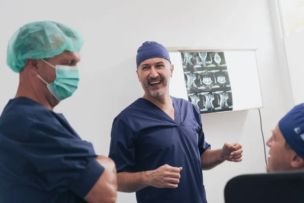 Equipo médico ortopedista que examina la imagen digital de rayos X en la clínica o el hospital —  Fotos de Stock