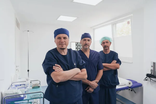 Médico ortopédico multiétnico frente a su equipo médico mirando a la cámara con máscara facial —  Fotos de Stock