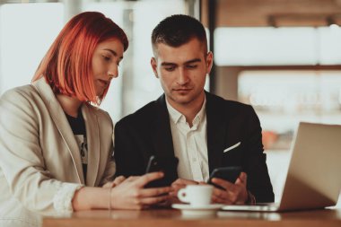 Modern erkek ve kadın modern cihazlar, dizüstü bilgisayar, tablet ve akıllı telefon kullanır ve iş için yeni projeler düzenler.