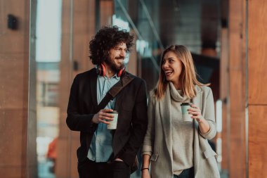 İki iş adamı, çalıştığı ve kahve içtiği endüstrinin yanından geçiyor.