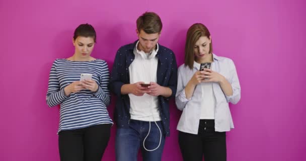 Studenti Sfondo Colorato Utilizzando Telefoni Cellulari Divertirsi Inviare Messaggio — Video Stock