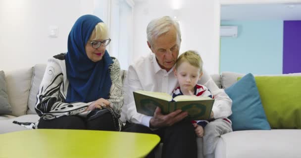 Tradycyjni Muzułmańscy Dziadkowie Dziećmi Czytający Koran Modlący Się Razem Kanapie — Wideo stockowe