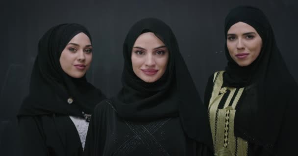 黒の黒板の背景に隔離されたヒジャーブと伝統的な中東のドレスで美しいイスラム教徒の女性のグループの肖像画 — ストック動画