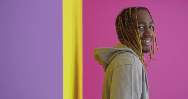 Портрет Молодого Афроамериканского Мужчины Улыбающегося Позирующего Цветном Фоне — стоковое видео