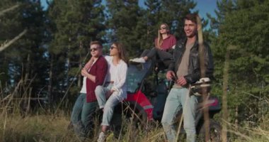 Bir grup genç hippi sabah güneşinin tadını çıkarıyor off-road arabasında ve macera ararken eğleniyorlar.