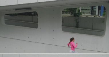 Şehir merkezinde şehir sokağında koşan genç bir bayan sporcu.. 