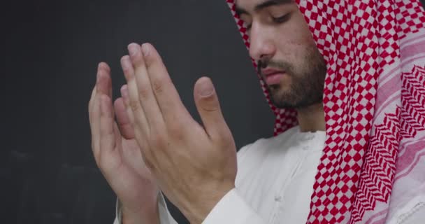 身穿传统服装的阿拉伯年轻人向上帝祈祷 在黑色黑板前保持双手祈祷的姿势 — 图库视频影像